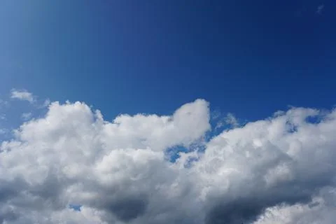 White fluffy clouds in the sky. Blue sky and cloud cover on a sunny summer da Stock Photos