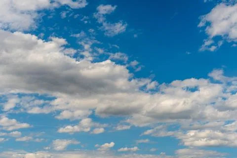White fluffy clouds in the sky. Blue sky and cloud cover on a sunny summer da Stock Photos
