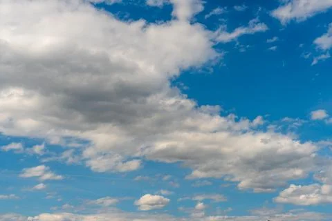 White fluffy clouds in the sky. Blue sky and cloud cover on a sunny summer da Stock Photos