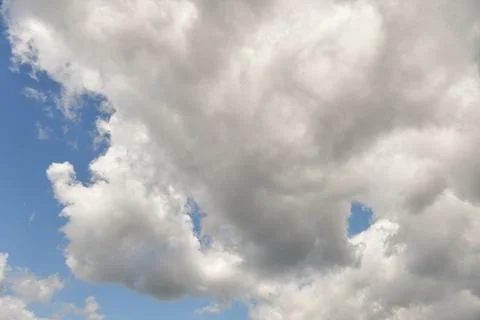 White fluffy clouds in the sky. Blue sky and cloud cover on a sunny summer da Stock Photos