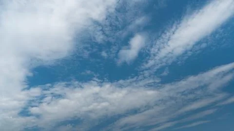 White fluffy clouds in the sky. Blue sky and cloud cover on a sunny summer da Stock Photos