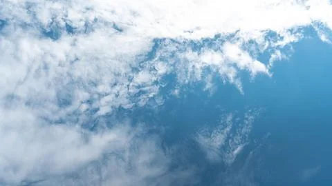 White fluffy clouds in the sky. Blue sky and cloud cover on a sunny summer da Stock Photos
