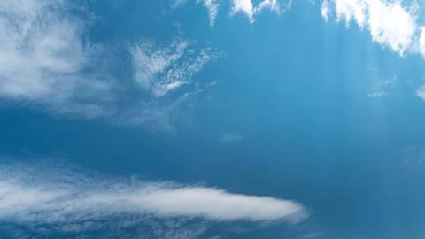 White fluffy clouds in the sky. Blue sky and cloud cover on a sunny summer da Stock Photos