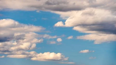 White fluffy clouds in the sky. Blue sky and cloud cover on a sunny summer da Stock Photos