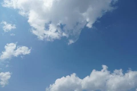 White fluffy clouds in the sky. Blue sky and cloud cover on a sunny summer da Stock Photos
