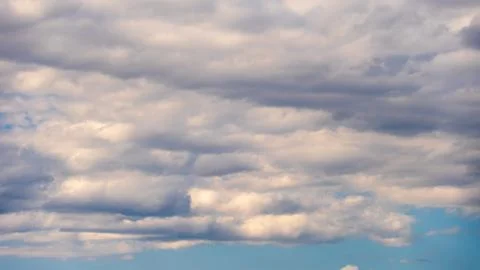 White fluffy clouds in the sky. Blue sky and cloud cover on a sunny summer da Stock Photos