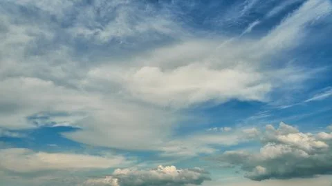 White fluffy clouds in the sky. Blue sky and cloud cover on a sunny summer da Stock Photos