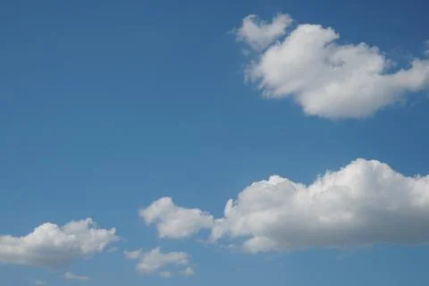 White fluffy clouds in the sky. Blue sky and cloud cover on a sunny summer da Stock Photos