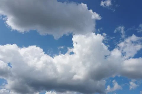 White fluffy clouds in the sky. Blue sky and cloud cover on a sunny summer da Stock Photos