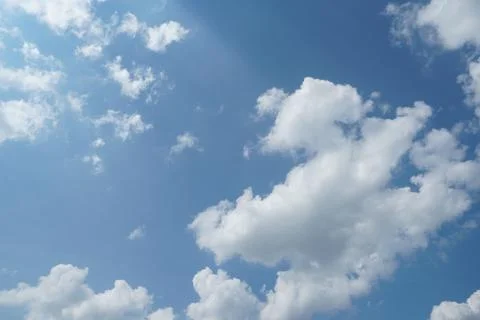 White fluffy clouds in the sky. Blue sky and cloud cover on a sunny summer da Stock Photos