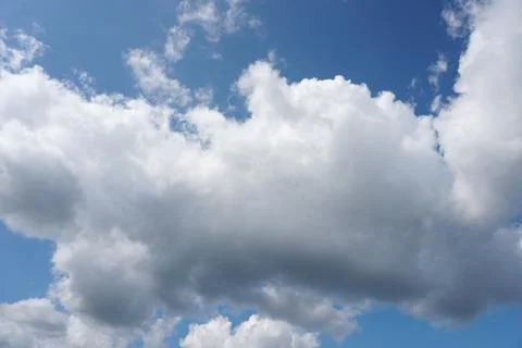 White fluffy clouds in the sky. Blue sky and cloud cover on a sunny summer da Stock Photos