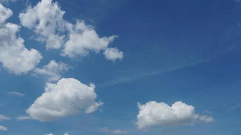 White fluffy clouds in the sky. Blue sky and cloud cover on a sunny summer da Stock Photos