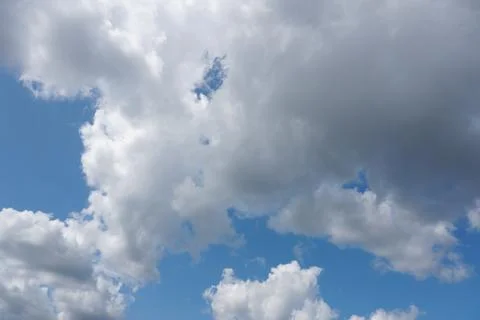 White fluffy clouds in the sky. Blue sky and cloud cover on a sunny summer da Stock Photos