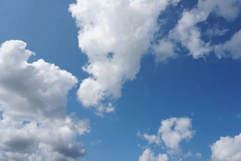 White fluffy clouds in the sky. Blue sky and cloud cover on a sunny summer da Stock Photos