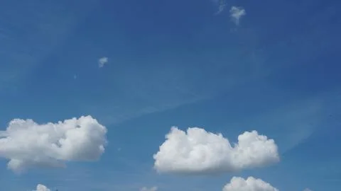 White fluffy clouds in the sky. Blue sky and cloud cover on a sunny summer da Stock Photos