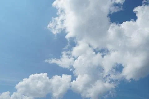 White fluffy clouds in the sky. Blue sky and cloud cover on a sunny summer da Stock Photos