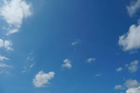 White fluffy clouds in the sky. Blue sky and cloud cover on a sunny summer da Stock Photos