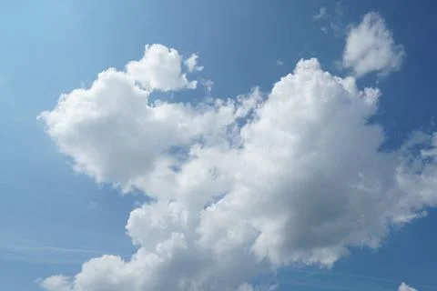 White fluffy clouds in the sky. Blue sky and cloud cover on a sunny summer da Stock Photos