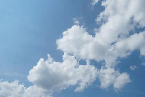 White fluffy clouds in the sky. Blue sky and cloud cover on a sunny summer da Stock Photos