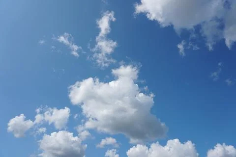 White fluffy clouds in the sky. Blue sky and cloud cover on a sunny summer da Stock Photos