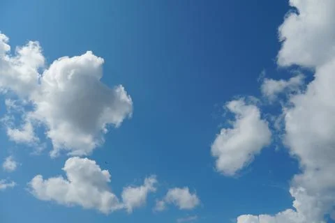 White fluffy clouds in the sky. Blue sky and cloud cover on a sunny summer da Stock Photos