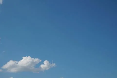 White fluffy clouds in the sky. Blue sky and cloud cover on a sunny summer da Stock Photos