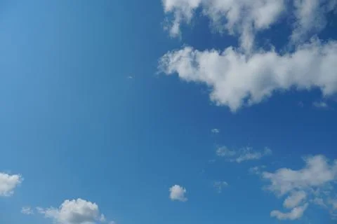 White fluffy clouds in the sky. Blue sky and cloud cover on a sunny summer da Stock Photos