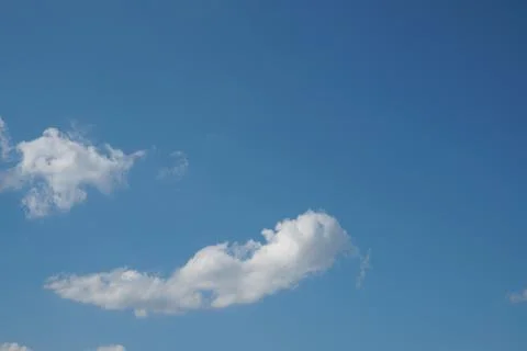 White fluffy clouds in the sky. Blue sky and cloud cover on a sunny summer da Stock Photos