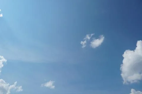 White fluffy clouds in the sky. Blue sky and cloud cover on a sunny summer da Stock Photos