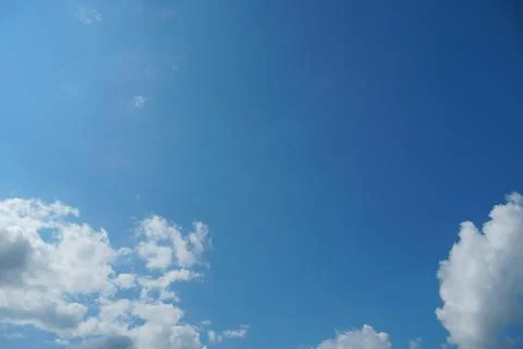 White fluffy clouds in the sky. Blue sky and cloud cover on a sunny summer da Stock Photos