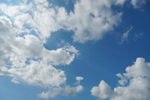 White fluffy clouds in the sky. Blue sky and cloud cover on a sunny summer da Stock Photos