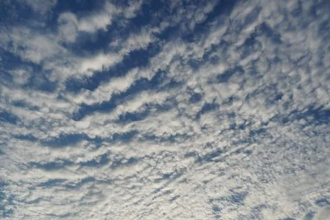 White fluffy clouds in the sky. Blue sky and cloud cover on a sunny summer da Stock Photos