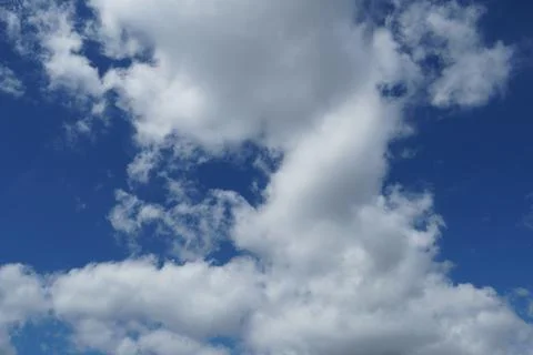 White fluffy clouds in the sky. Blue sky and cloud cover on a sunny summer da Stock Photos