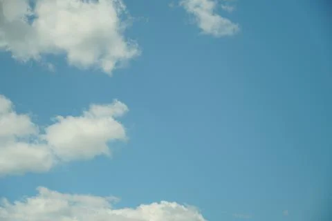 White fluffy clouds in the sky. Blue sky and cloud cover on a sunny summer da Stock Photos