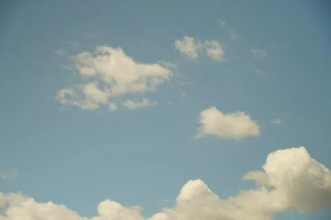 White fluffy clouds in the sky. Blue sky and cloud cover on a sunny summer da Stock Photos