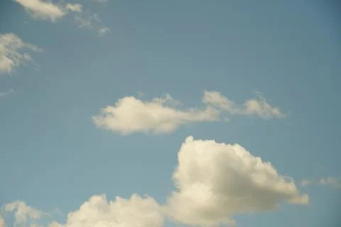 White fluffy clouds in the sky. Blue sky and cloud cover on a sunny summer da Stock Photos