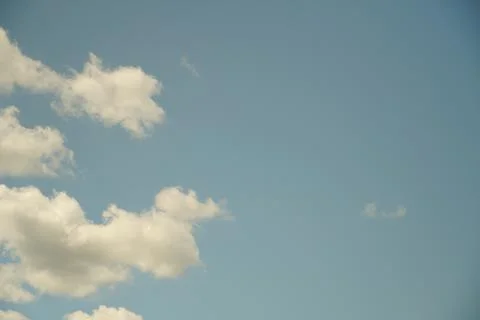 White fluffy clouds in the sky. Blue sky and cloud cover on a sunny summer da Stock Photos