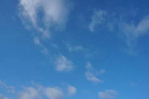 White fluffy clouds in the sky. Blue sky and cloud cover on a sunny summer da Stock Photos