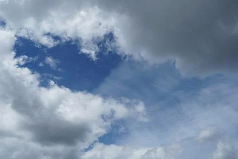 White fluffy clouds in the sky. Blue sky and cloud cover on a sunny summer da Stock Photos
