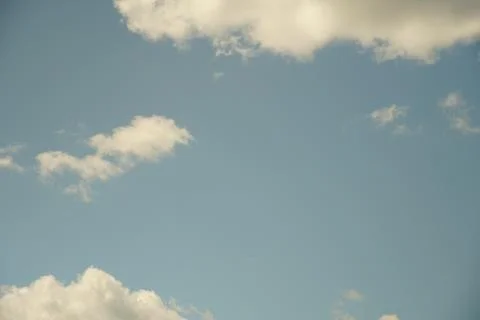 White fluffy clouds in the sky. Blue sky and cloud cover on a sunny summer da Stock Photos