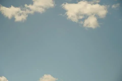 White fluffy clouds in the sky. Blue sky and cloud cover on a sunny summer da Stock Photos