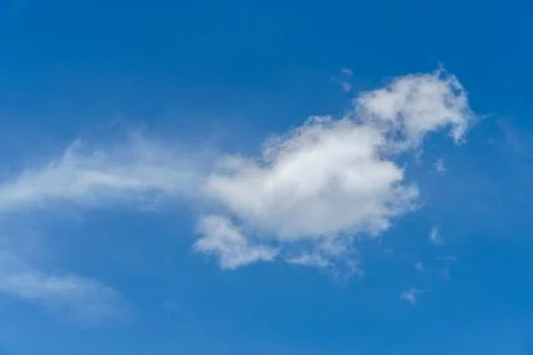 White fluffy clouds in the sky. Blue sky and cloud cover on a sunny summer da Stock Photos