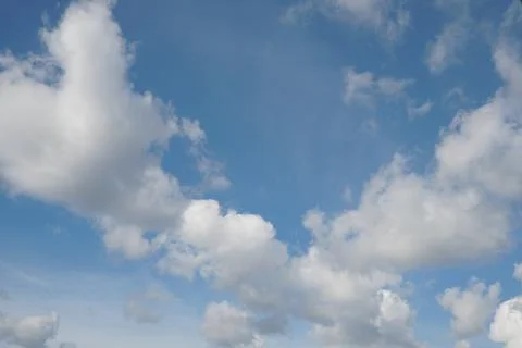 White fluffy clouds in the sky. Blue sky and cloud cover on a sunny summer da Stock Photos