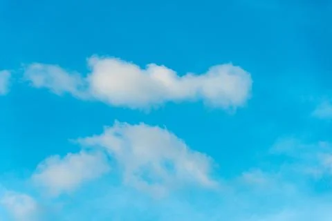 White fluffy clouds in the sky. Blue sky and cloud cover on a sunny summer da Stock Photos
