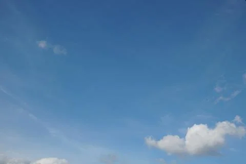 White fluffy clouds in the sky. Blue sky and cloud cover on a sunny summer da Stock Photos