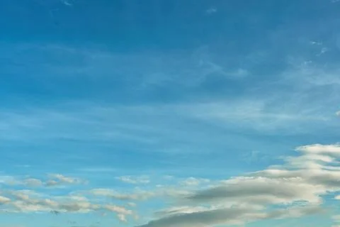 White fluffy clouds in the sky. Blue sky and cloud cover on a sunny summer da Stock Photos