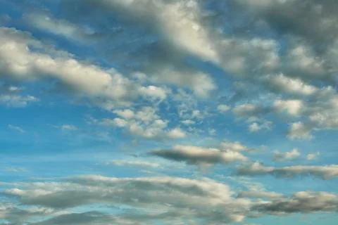 White fluffy clouds in the sky. Blue sky and cloud cover on a sunny summer da Stock Photos