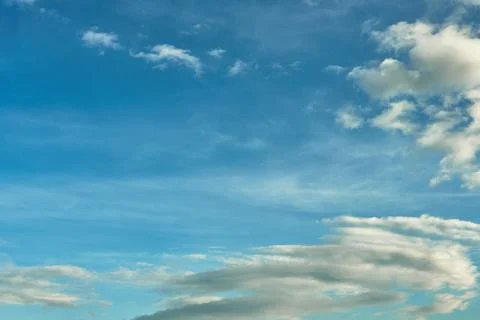 White fluffy clouds in the sky. Blue sky and cloud cover on a sunny summer da Stock Photos