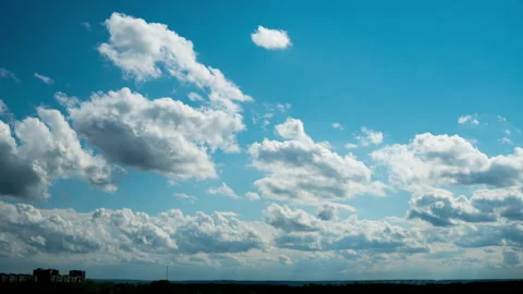 White Fluffy Clouds Slowly Float Through the Blue Daytime Sky Timelapse Stock Footage 192983900