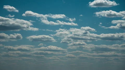 White Fluffy Clouds Slowly Float Through the Blue Daytime Sky Timelapse Stock Footage 194579758